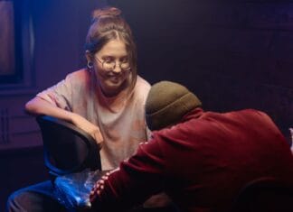 Tatuator celebryta czy lokalny artysta jak wybrać kogoś dla siebie Tatuator projektuje wzór dla klienta w przytulnym studiu tatuażu