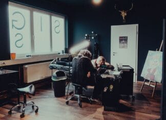 Tatuażysta przy pracy z klientem w nowoczesnym studiu tatuażu